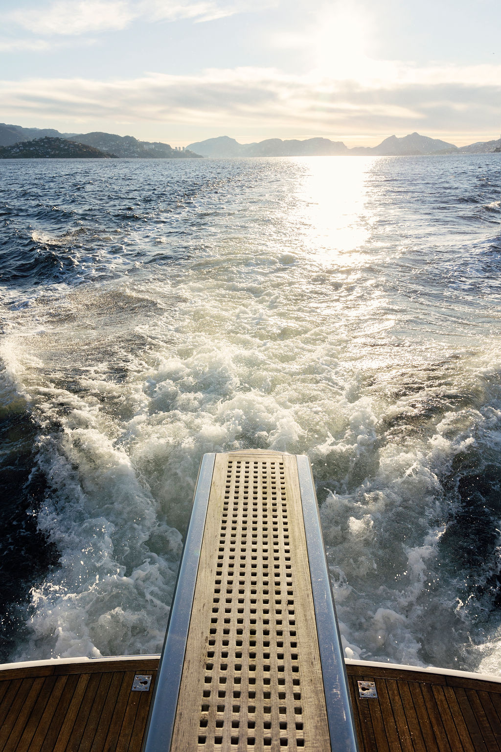 View from the aft landing of the private cruise yacht. Taken on the fjords while the sun is setting.